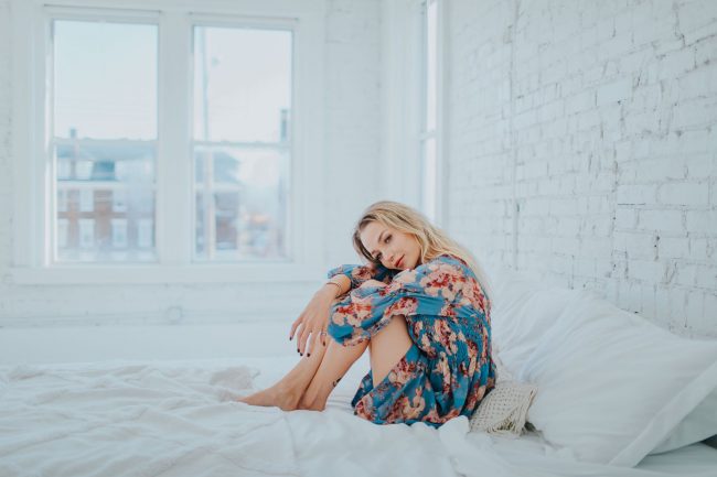 pexels-photo-3586911 woman wearing floral dress while sitting on bed
