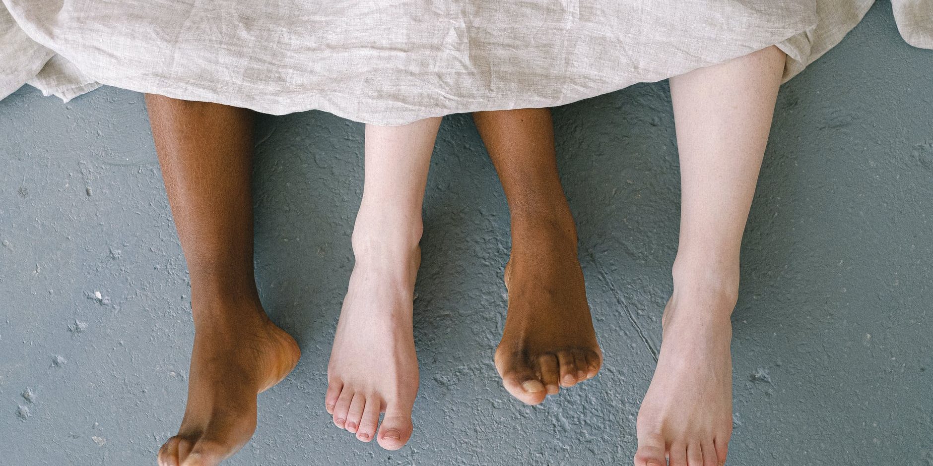 bare feet coming out of bed sheets