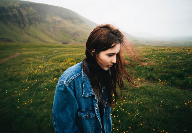 pexels-photo-919605 woman wearing blue denim jacket walking on the green grass field